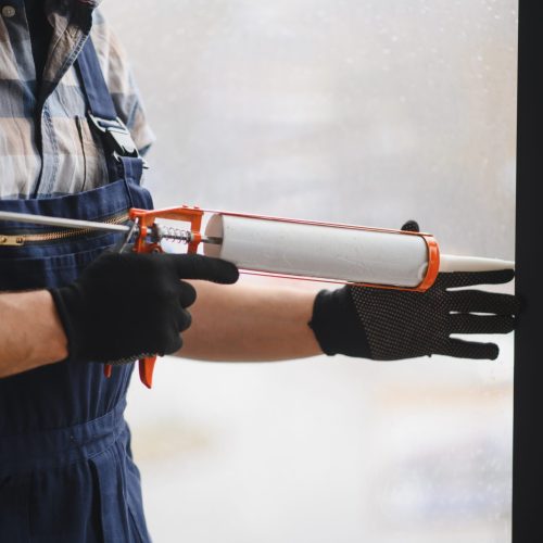 Construction,Worker,Uses,Sealant,Gun,During,Window,Installation,,Ensuring,Airtight